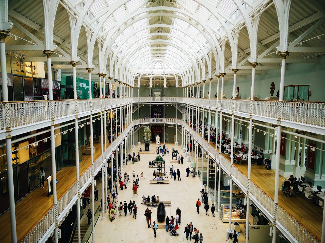 Interior view of the National Museum of Scotland's grand hall with visitors exploring exhibits.